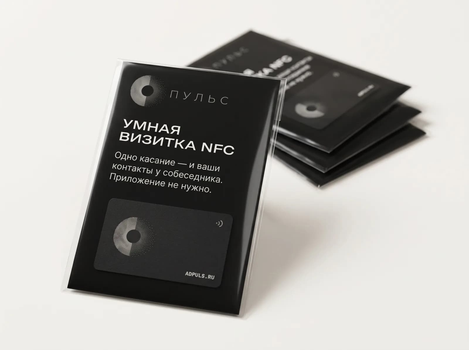 NFC-карта 42 × 26 мм на чёрном вкладыше «Умная визитка NFC» в прозрачном пакете, позади стопка таких же упаковок